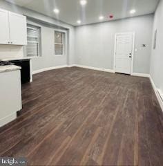 unfurnished living room with dark wood-type flooring