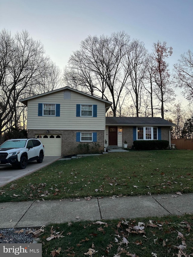 tri-level home with a garage and a yard