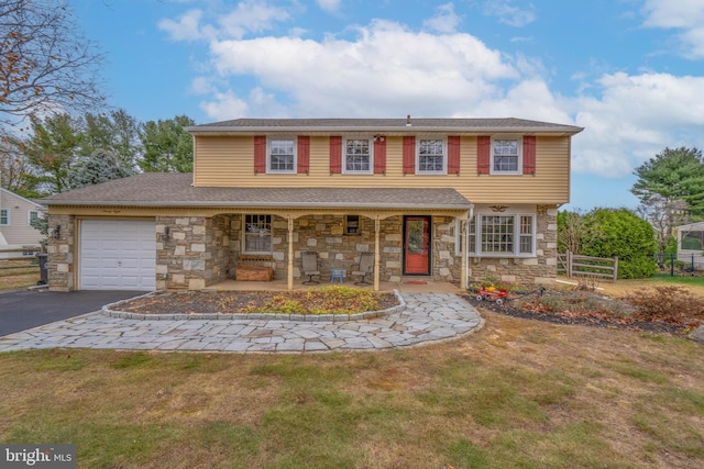 view of front of home with a front yard, a porch, and a garage