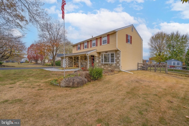 view of front of home featuring covered porch and a front yard