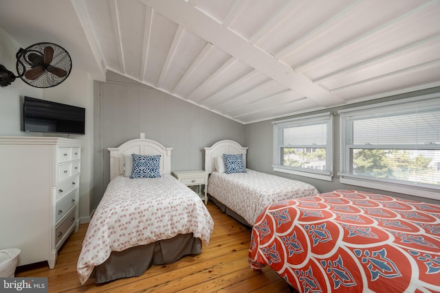 bedroom with vaulted ceiling with beams and light hardwood / wood-style flooring