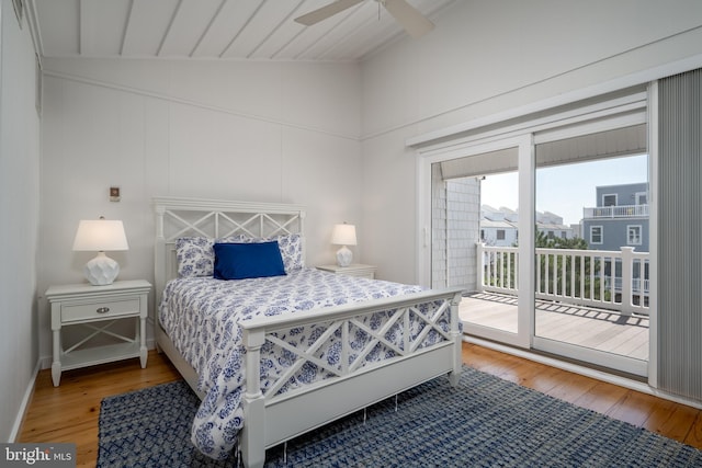 bedroom featuring access to exterior, hardwood / wood-style floors, vaulted ceiling, and ceiling fan