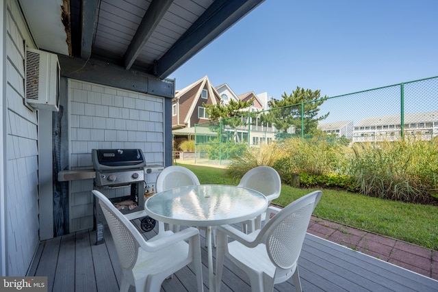 wooden terrace with a lawn and a grill