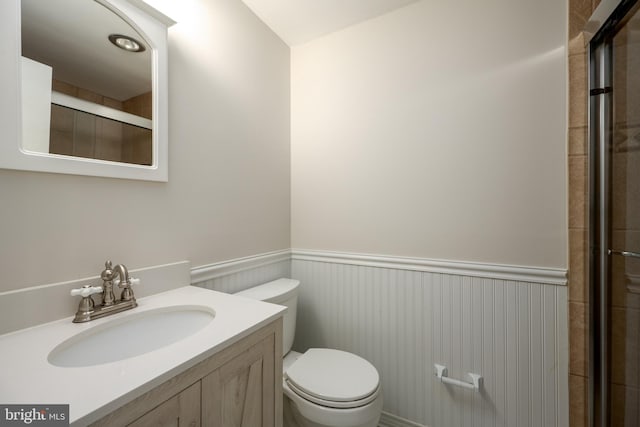 bathroom with vanity, an enclosed shower, and toilet