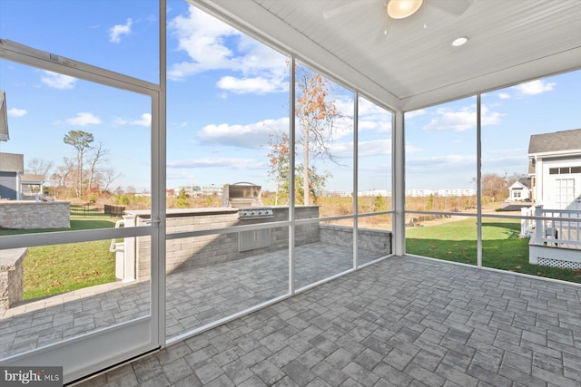 unfurnished sunroom featuring ceiling fan