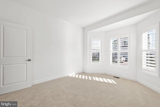 unfurnished room featuring light carpet