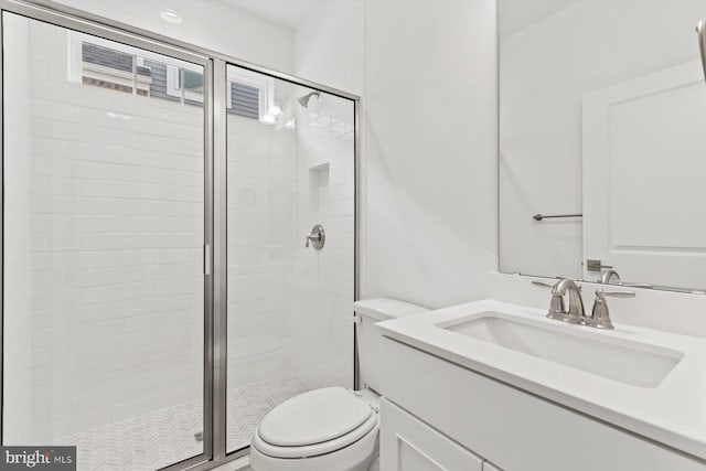 bathroom with vanity, a shower with shower door, and toilet