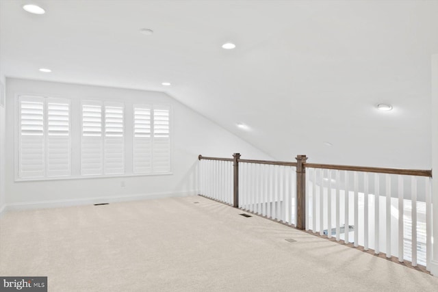 additional living space featuring light carpet and lofted ceiling