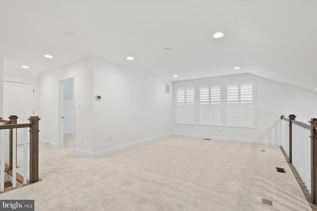 bonus room with light carpet and vaulted ceiling