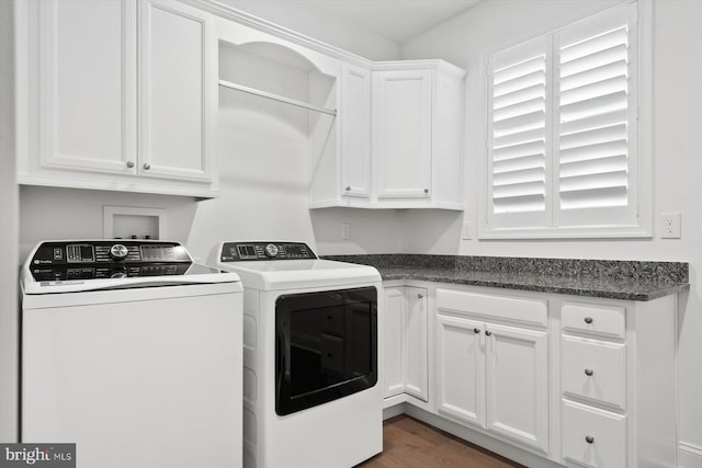 washroom with cabinets, washing machine and dryer, and dark wood-type flooring