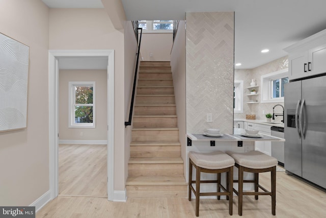 stairs with hardwood / wood-style floors and sink