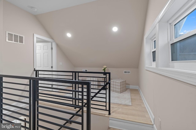 stairway featuring hardwood / wood-style floors and vaulted ceiling