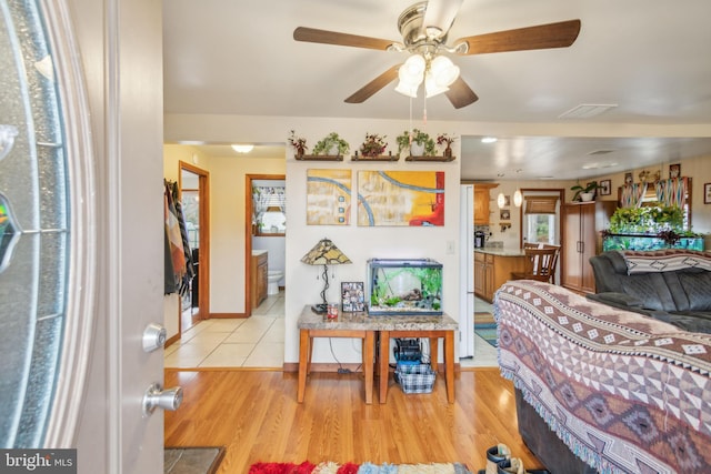 living room with light wood-type flooring and ceiling fan