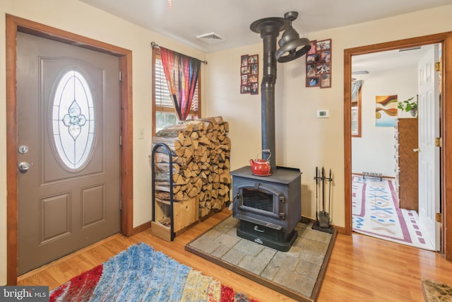 foyer with a wood stove and light hardwood / wood-style flooring