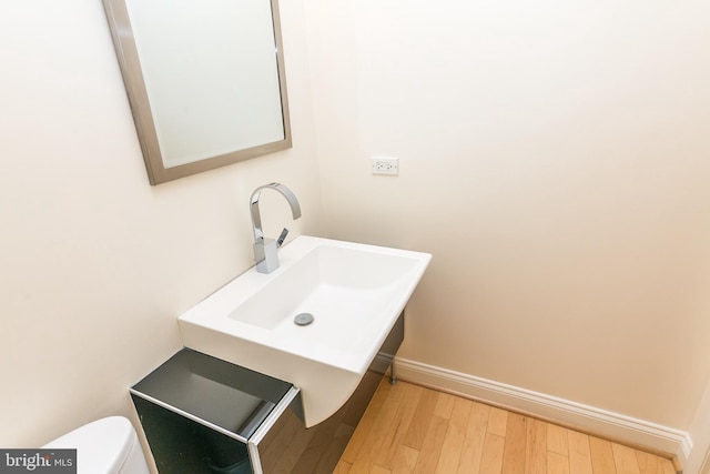 bathroom with sink, toilet, and hardwood / wood-style flooring