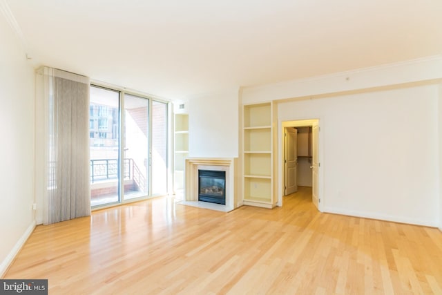 unfurnished living room featuring crown molding and light hardwood / wood-style floors