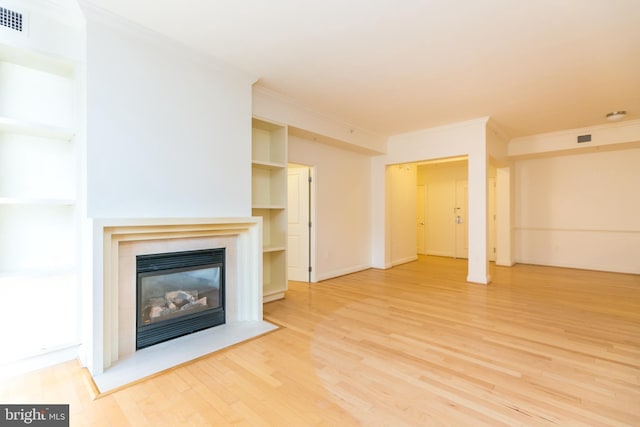 unfurnished living room with ornamental molding and hardwood / wood-style flooring