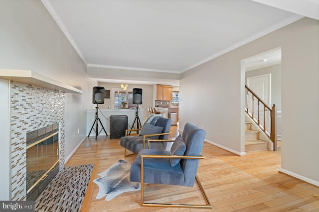 living room with crown molding, a fireplace, and light hardwood / wood-style floors