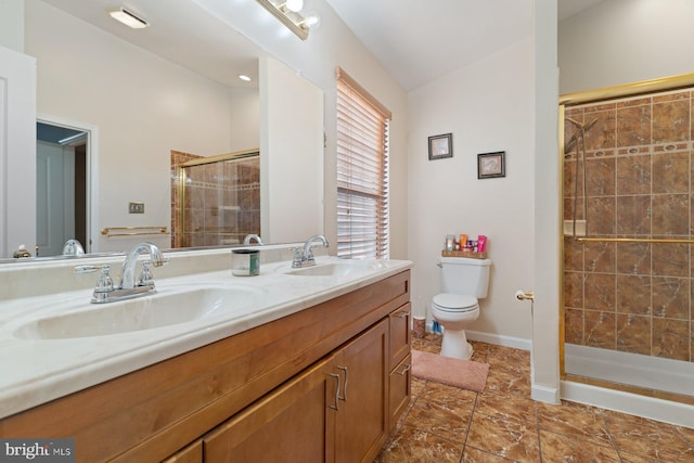 bathroom with vanity, toilet, and a shower with shower door