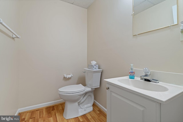 bathroom featuring a paneled ceiling, vanity, toilet, and hardwood / wood-style floors