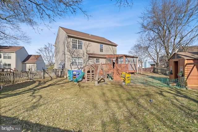 rear view of property featuring a playground and a lawn