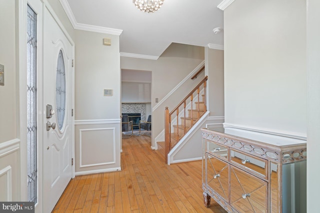 entryway featuring crown molding and light hardwood / wood-style flooring