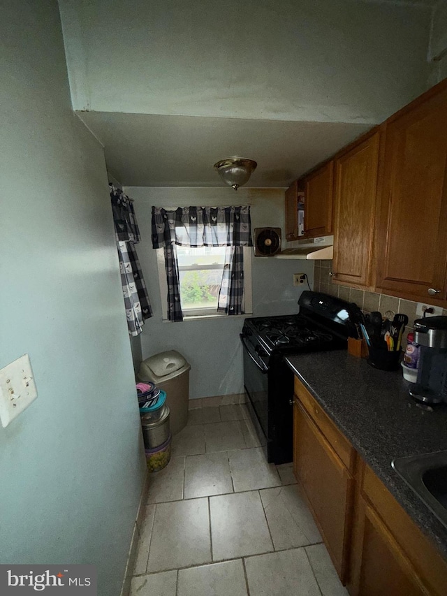 kitchen with sink, black range oven, and light tile patterned floors