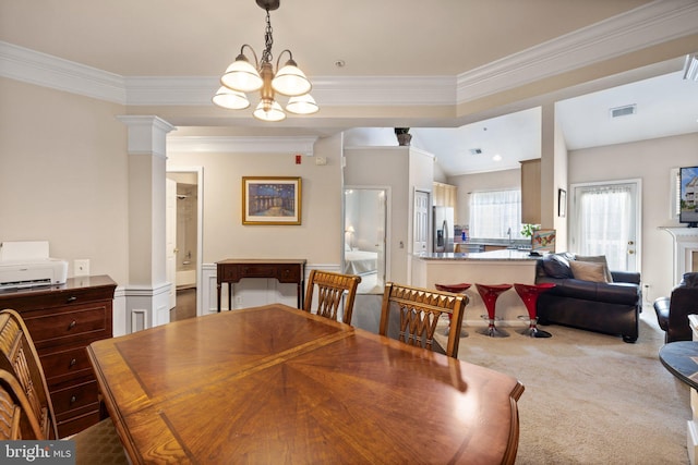 dining area with decorative columns, carpet, visible vents, and ornamental molding