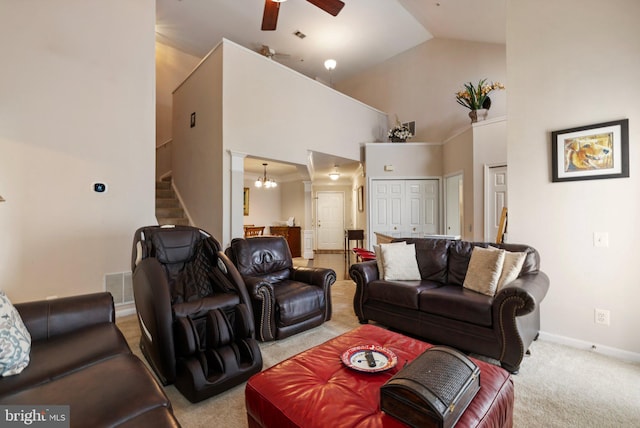 living area with baseboards, stairs, carpet floors, ceiling fan with notable chandelier, and high vaulted ceiling