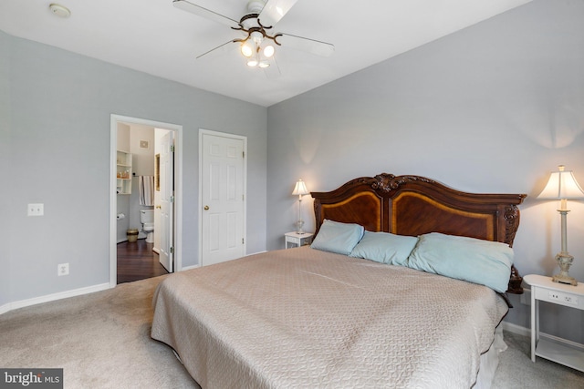 bedroom featuring ensuite bath, baseboards, carpet floors, and ceiling fan