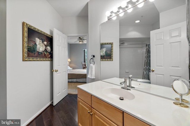 full bathroom featuring wood finished floors, connected bathroom, baseboards, ceiling fan, and vanity