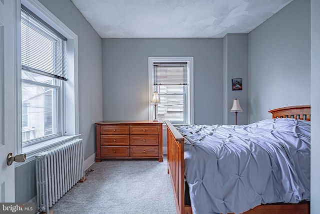 bedroom with radiator heating unit and light colored carpet