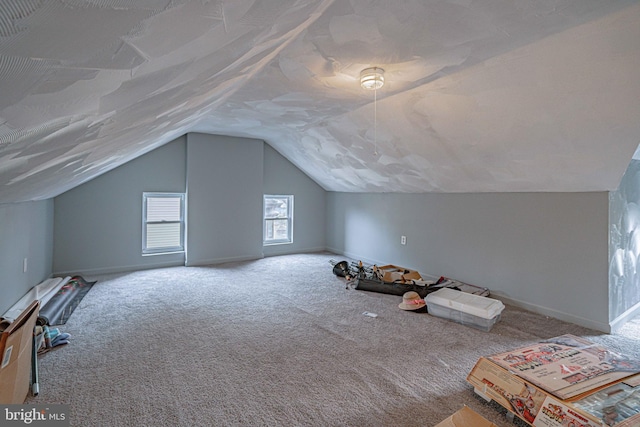 additional living space featuring carpet floors and vaulted ceiling