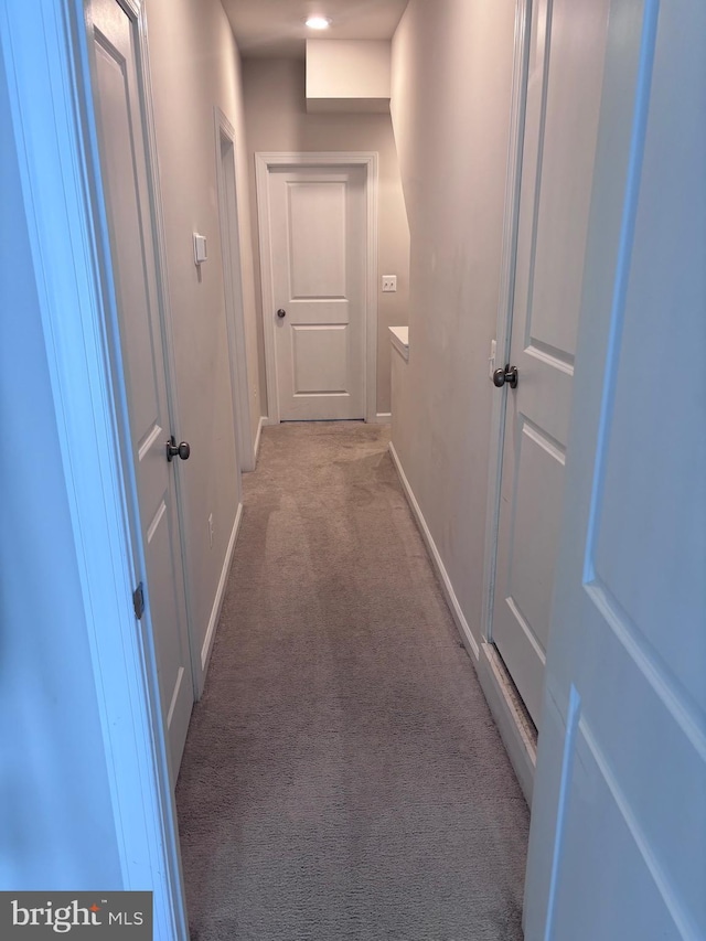 corridor featuring light colored carpet