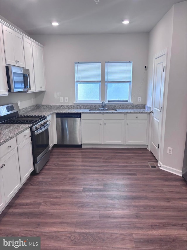 kitchen featuring white cabinets, dark hardwood / wood-style floors, and appliances with stainless steel finishes