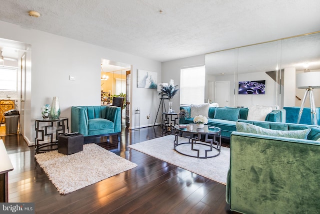 living room featuring a textured ceiling and dark wood-type flooring