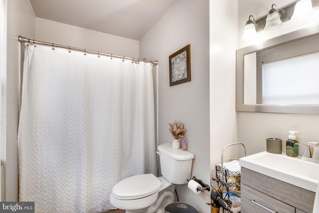 bathroom with vanity, curtained shower, and toilet