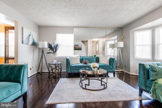 living room with dark hardwood / wood-style floors and a textured ceiling