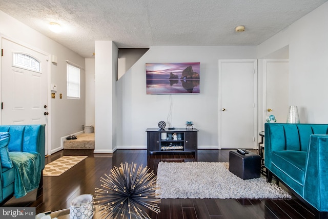 living room with a textured ceiling and dark hardwood / wood-style flooring