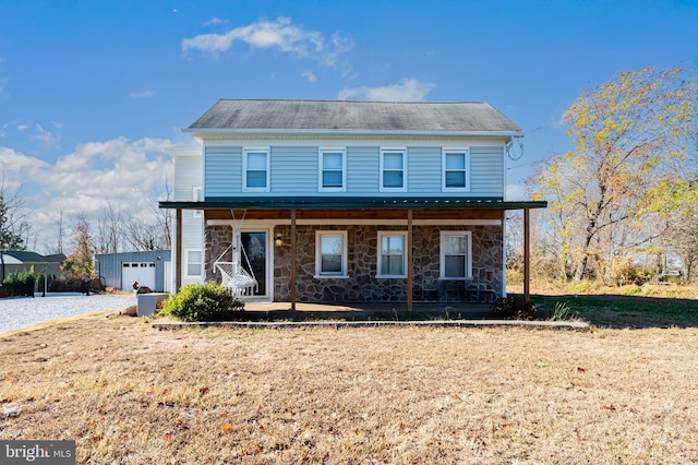 view of front of property with a porch, a garage, and an outdoor structure