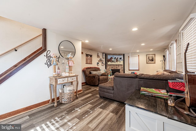 living room with a fireplace and dark wood-type flooring