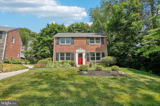 colonial inspired home featuring a front lawn