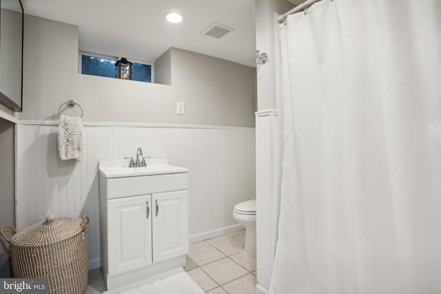 bathroom with tile patterned flooring, vanity, and toilet