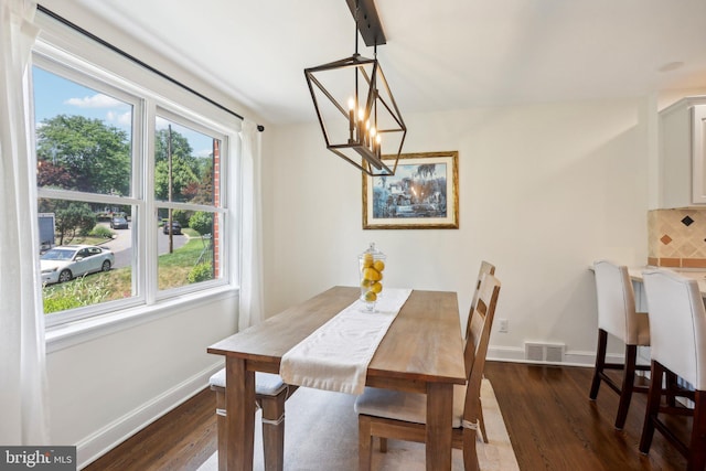 dining space featuring a chandelier and dark hardwood / wood-style flooring