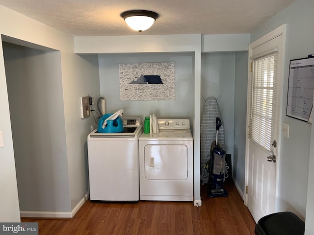 clothes washing area with a textured ceiling, washing machine and clothes dryer, and dark hardwood / wood-style flooring