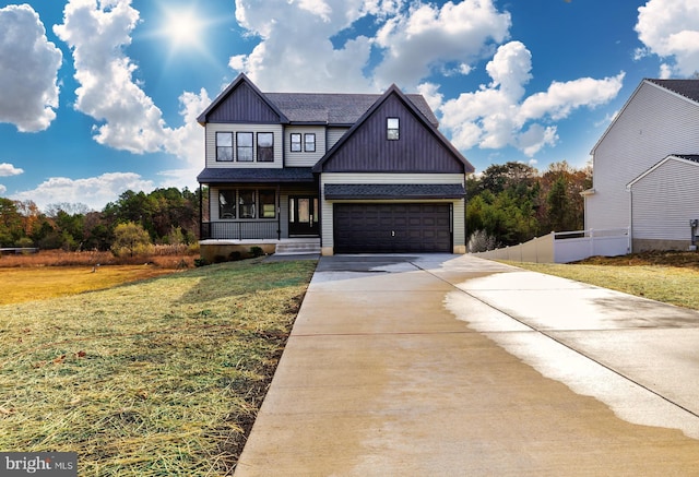 view of front of home featuring a porch, a garage, and a front lawn