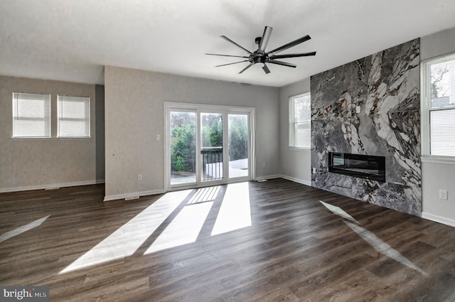 unfurnished living room with dark hardwood / wood-style floors, ceiling fan, and a premium fireplace