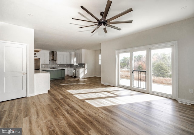 unfurnished living room with ceiling fan and hardwood / wood-style floors