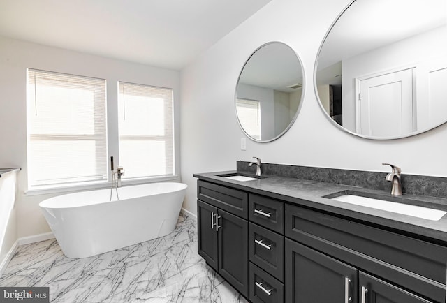 bathroom with a washtub and vanity