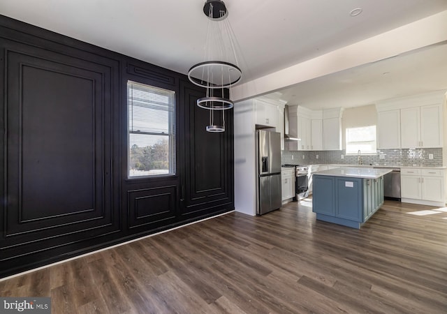 kitchen with plenty of natural light, a kitchen island, white cabinetry, and appliances with stainless steel finishes